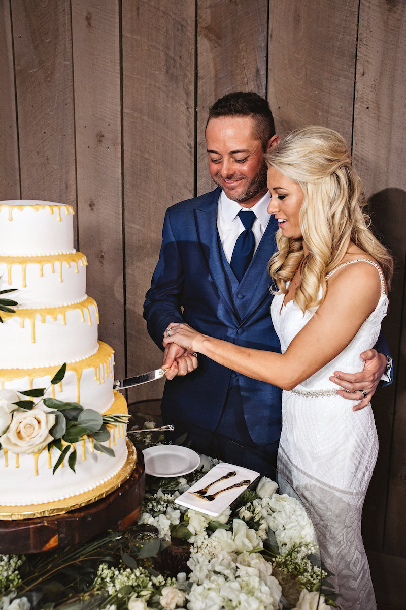 Bride and groom cutting wedding cake at barn wedding at Spring Creek Ranch in Tennessee